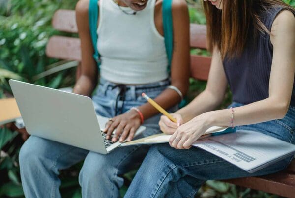 Online students with laptop and taking notes