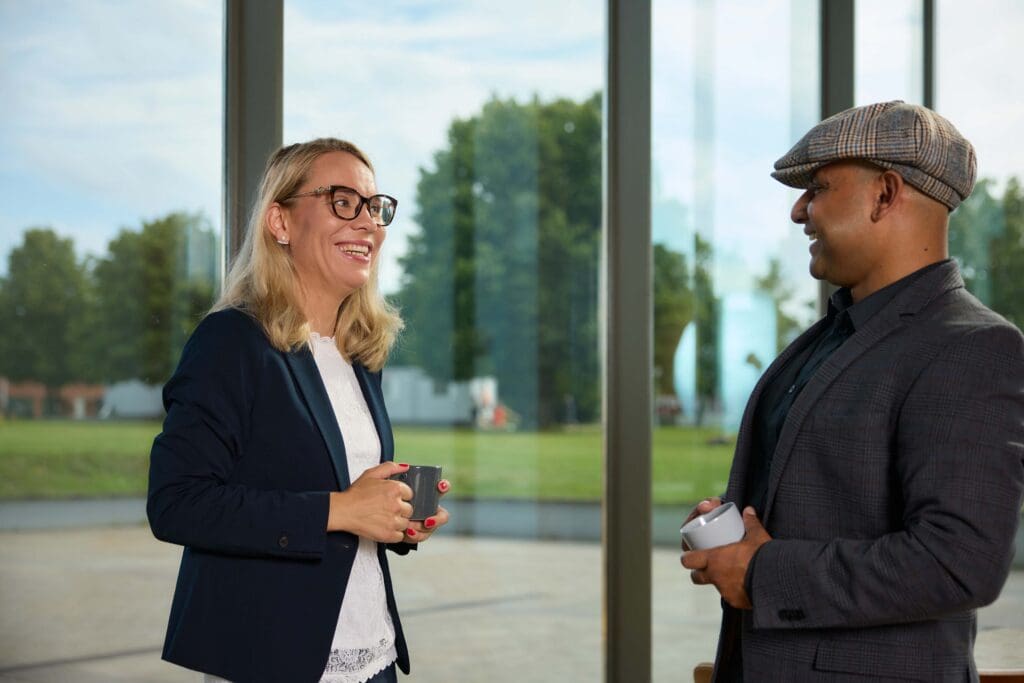 A female and male researcher discussing outside