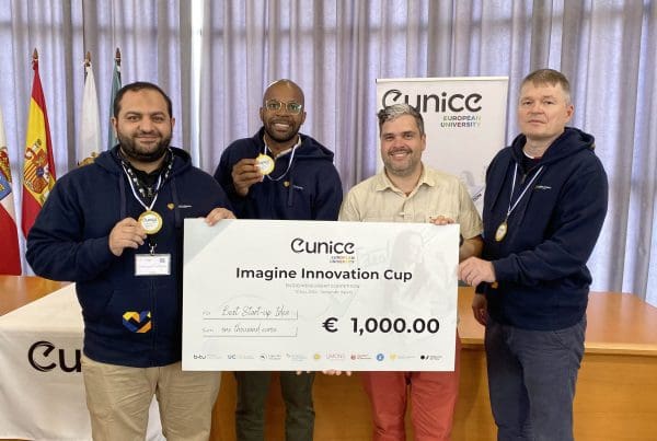 Team representing University of Vaasa with their "UNICORE" project, holding their 1,000-euro cheque