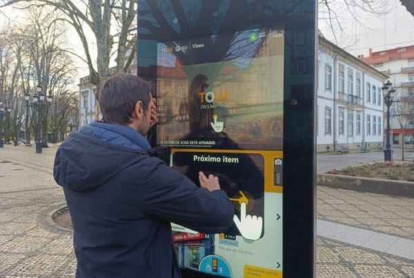 A person covering their eyes and touching a TOMI Interactive touchscreen on the street